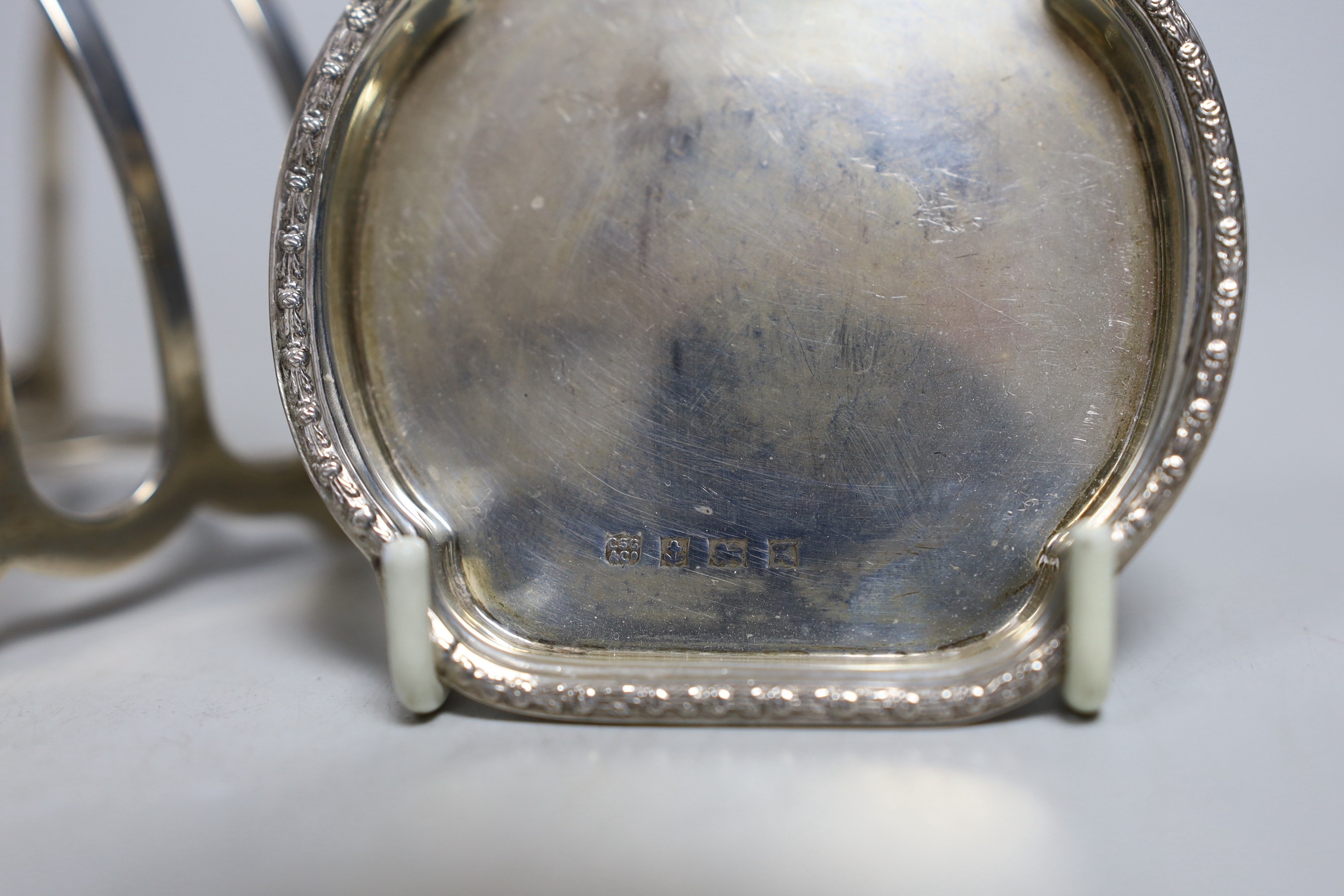A George V silver seven bar toast rack by William Hutton & Sons, 12.2cm and two silver small pin dishes.